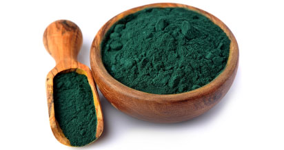 Spirulina Powder in a Wooden Scoop and Bowl